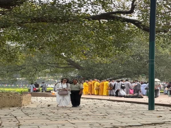 Senior Buddhist Pilgrim in Lumbini with monks in the background